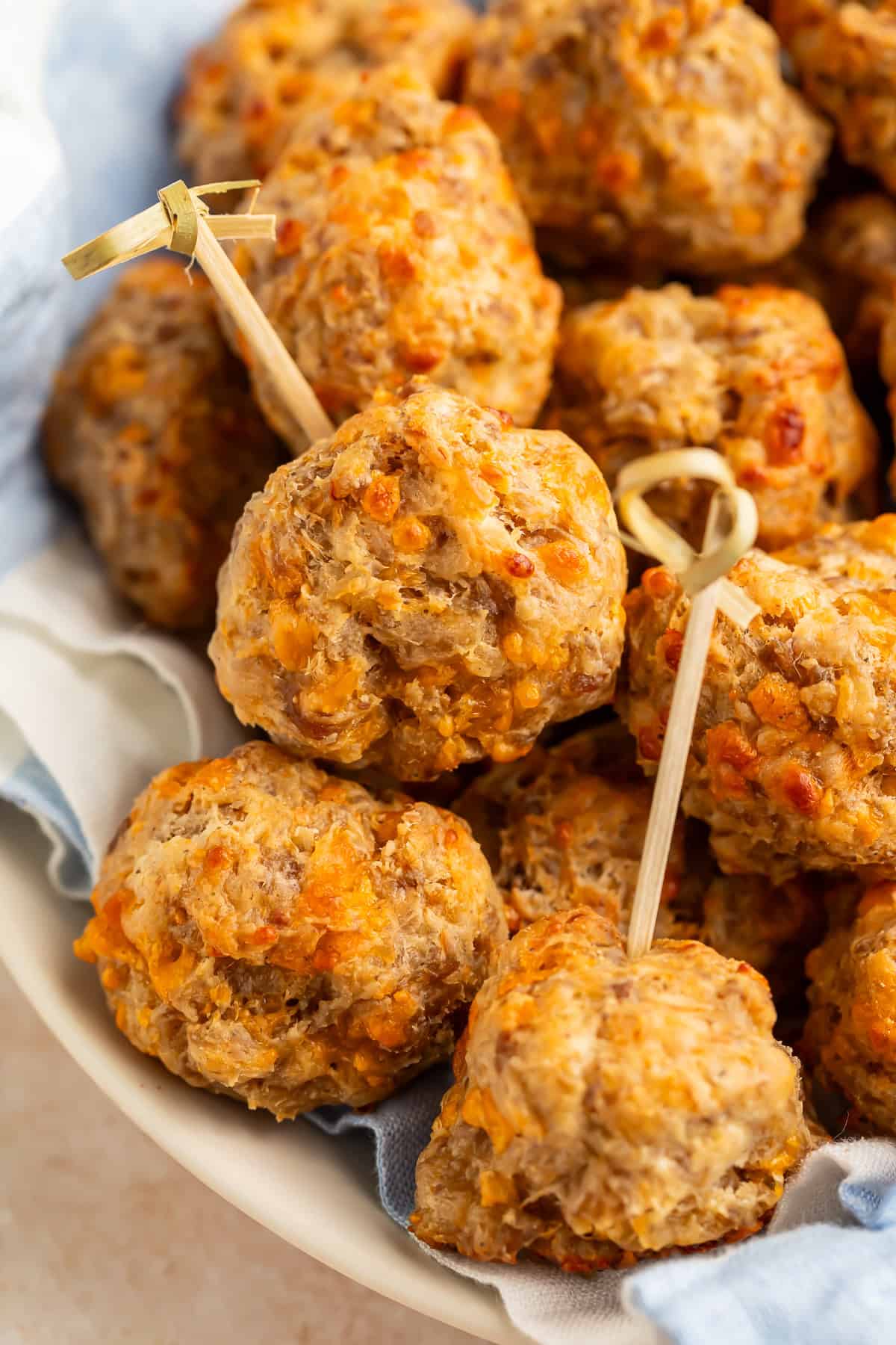 Close up of a bowl of cream cheese sausage bowls with curl-topped toothpicks in the top of two of them.