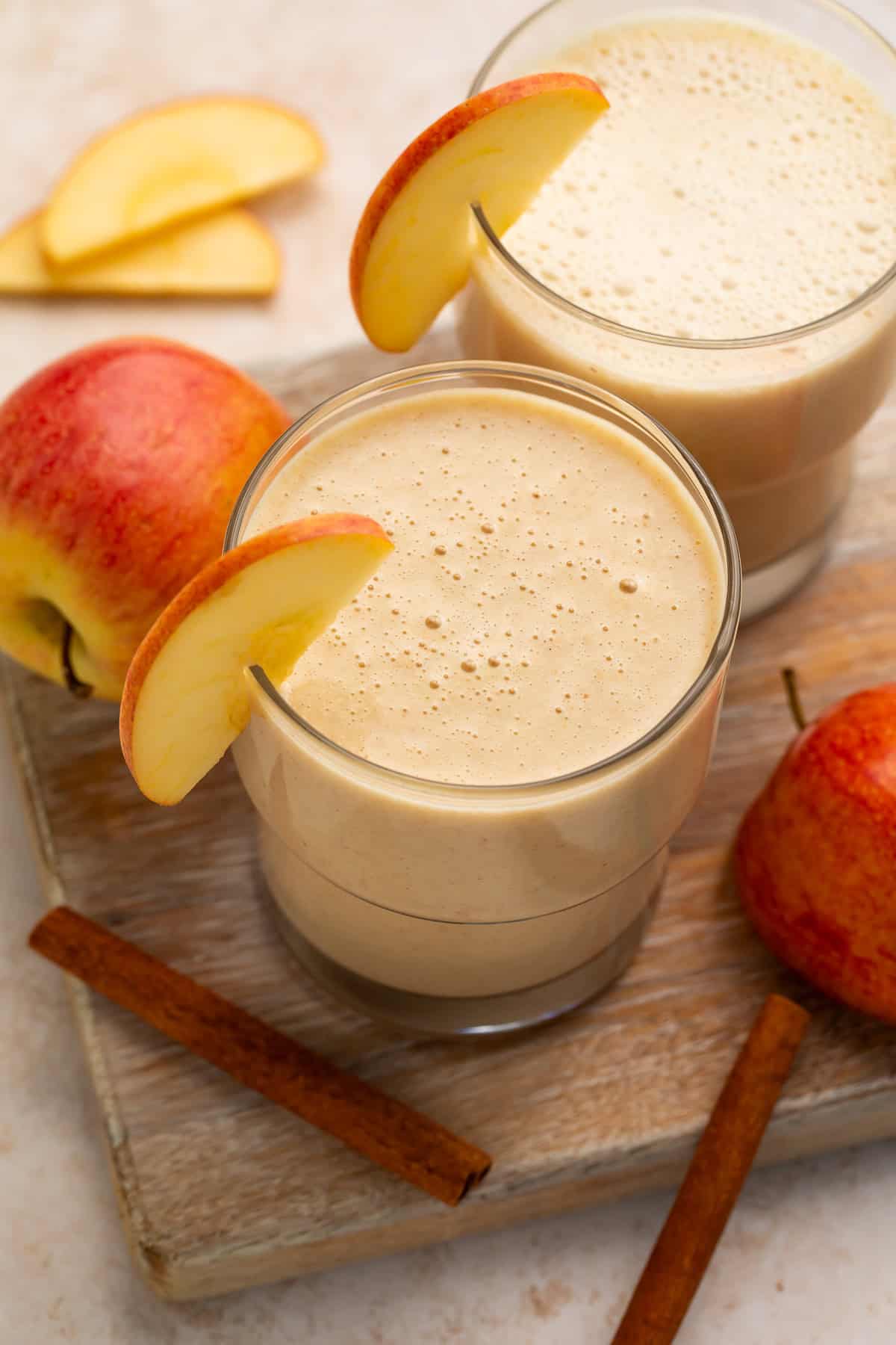 Overhead view of a pair of smoothies garnished with fresh apple.