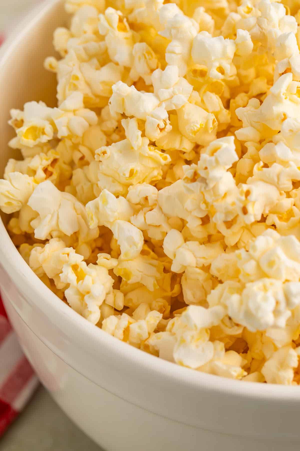 Close up of a white bowl of popcorn.