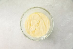 Melted mozzarella and cream cheese in a glass bowl on a marble background
