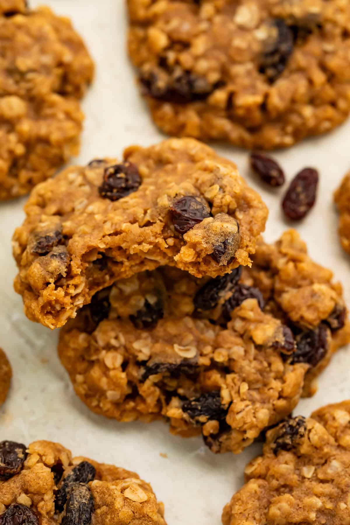 Close up of stacked oatmeal raisin cookies with a bite taken out of them.