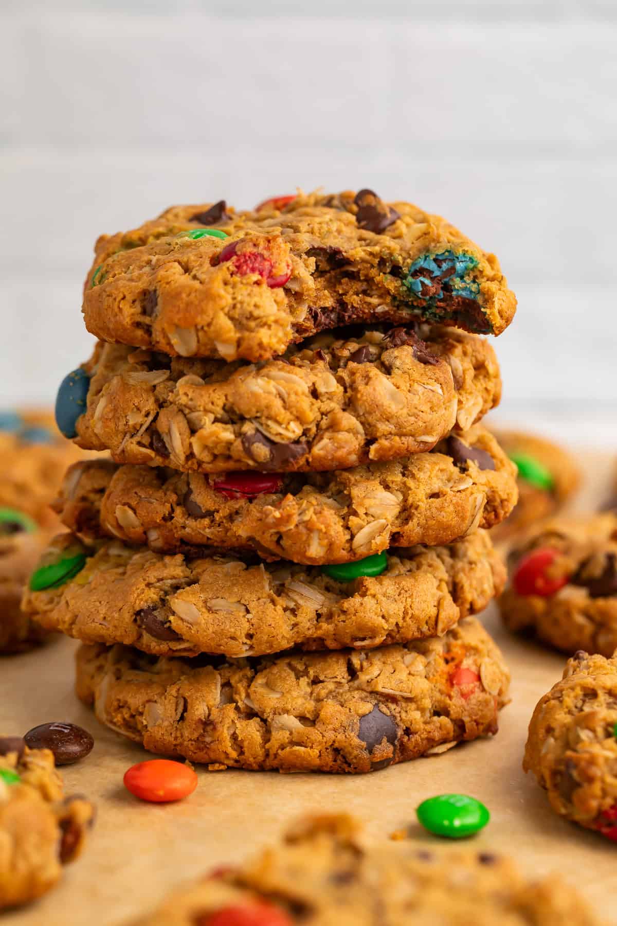 Close up of a stack of monster cookies with a bite taken out of the top one.