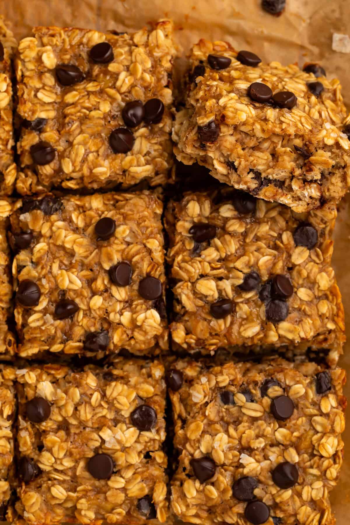 Chocolate chip oatmeal bars on a piece of brown baking parchment.