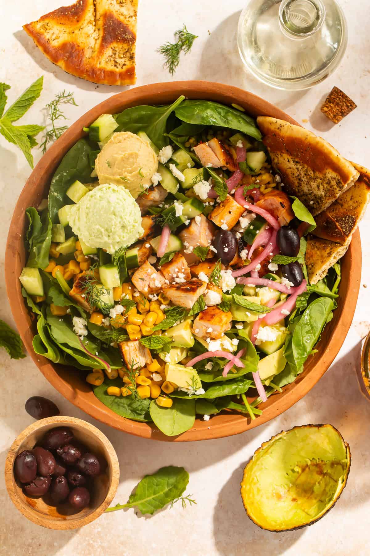 Harissa avocado bowl with chicken, hummus, Crazy Feta, and pita wedges