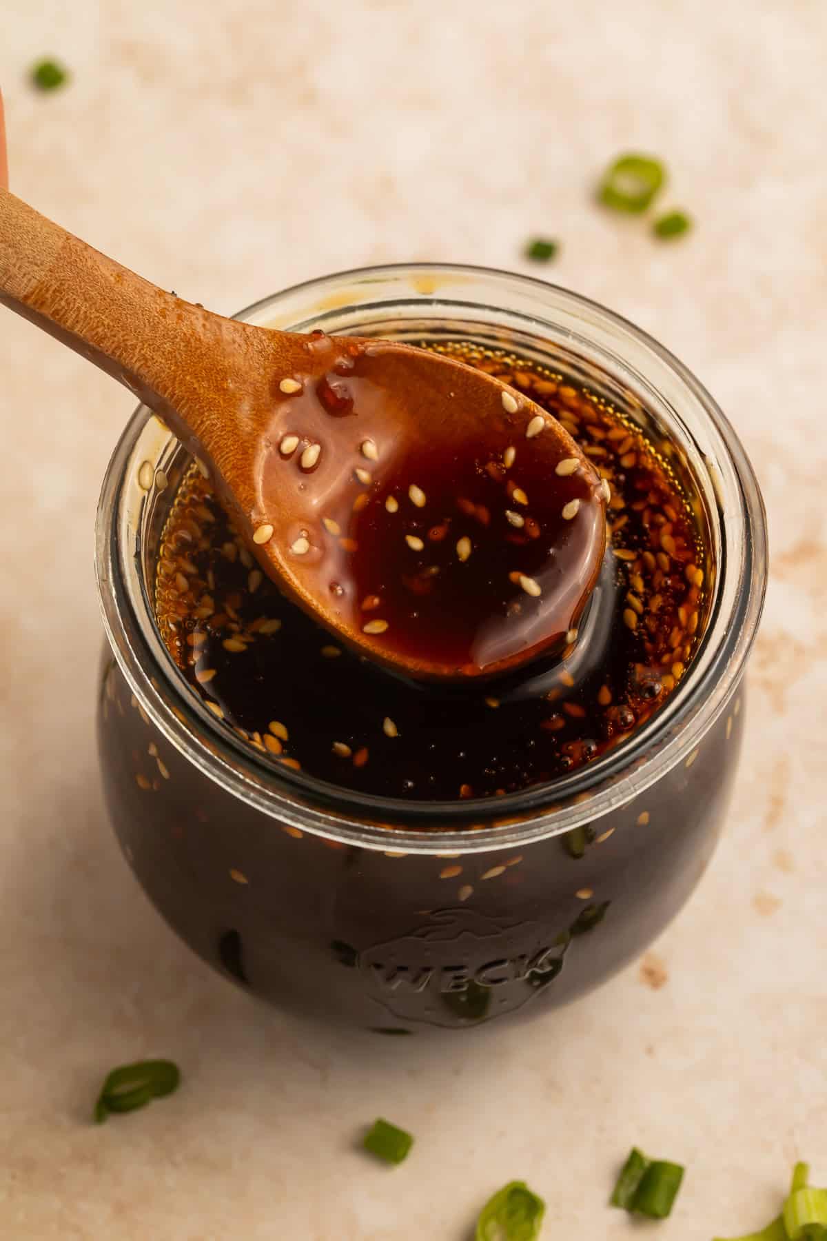 Spoonful of homemade teriyaki sauce over a jar of sauce