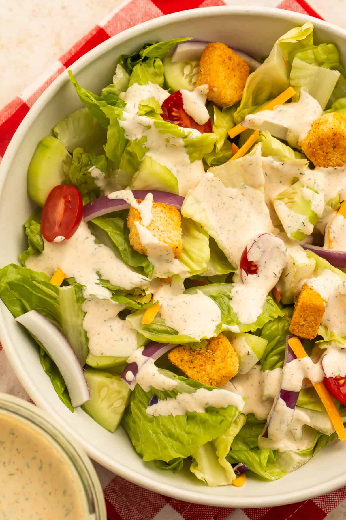 Homemade Outback ranch dressing in a glass jar served beside a garden salad.