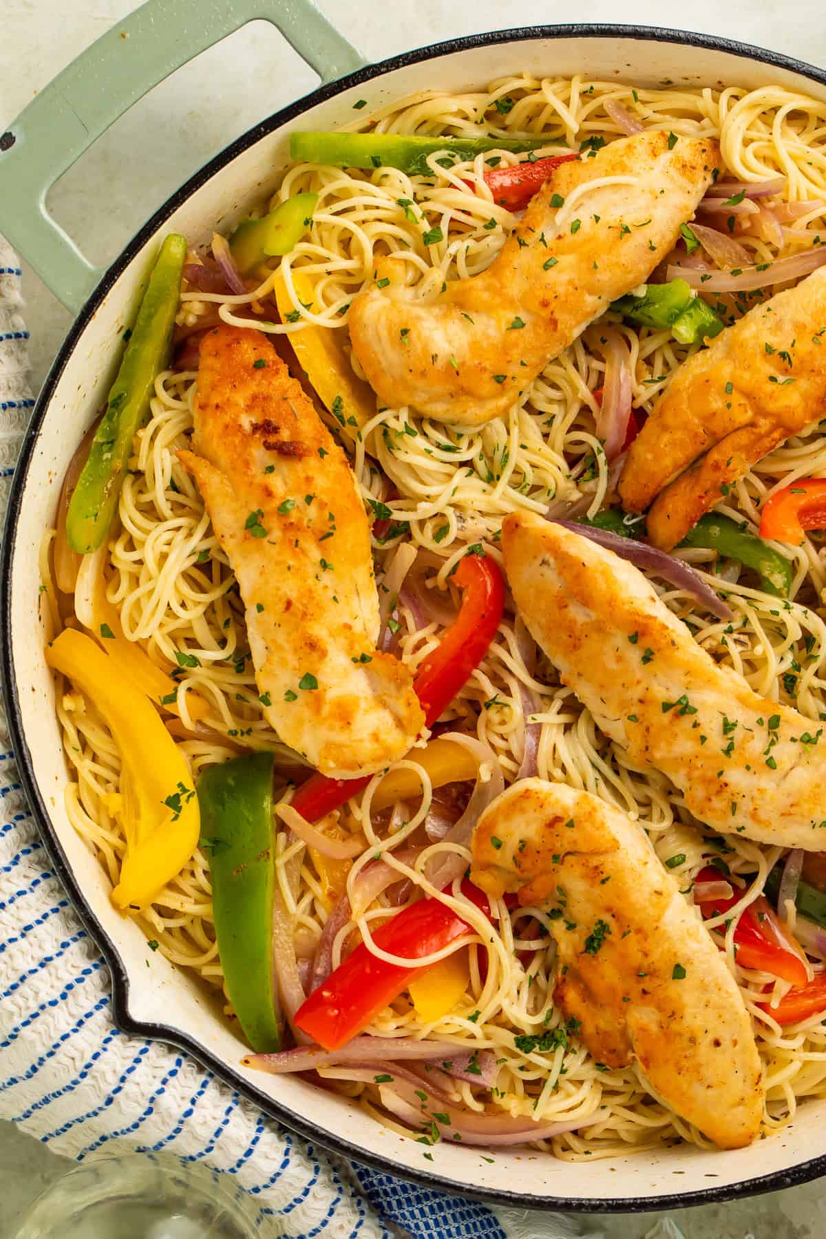 Copycat Olive Garden chicken scampi with golden chicken tenders, angel hair pasta, bell peppers, and red onion.