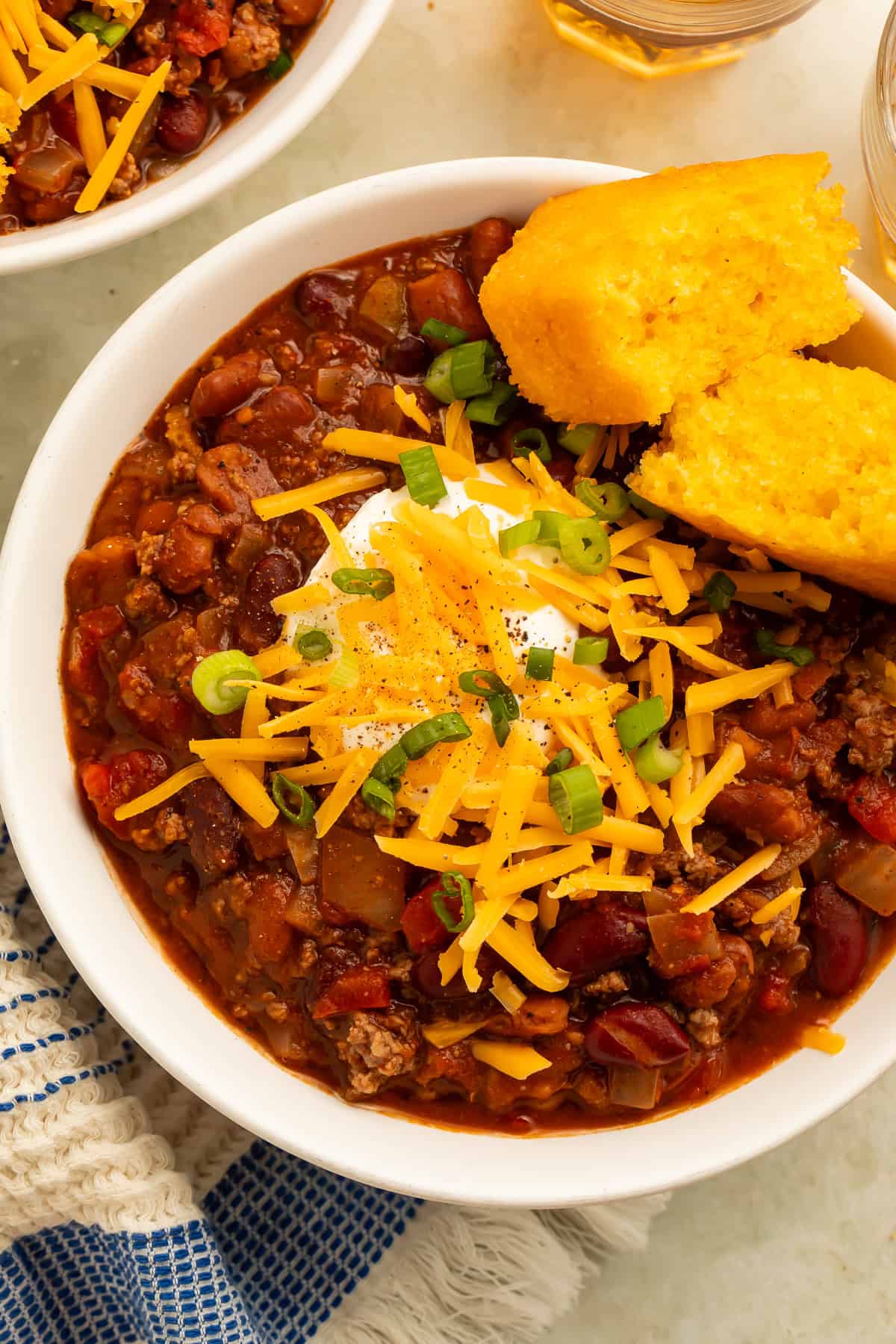Bison chili with kidney beans, tomatoes, cheddar cheese, sour cream, green onions, and cornbread.