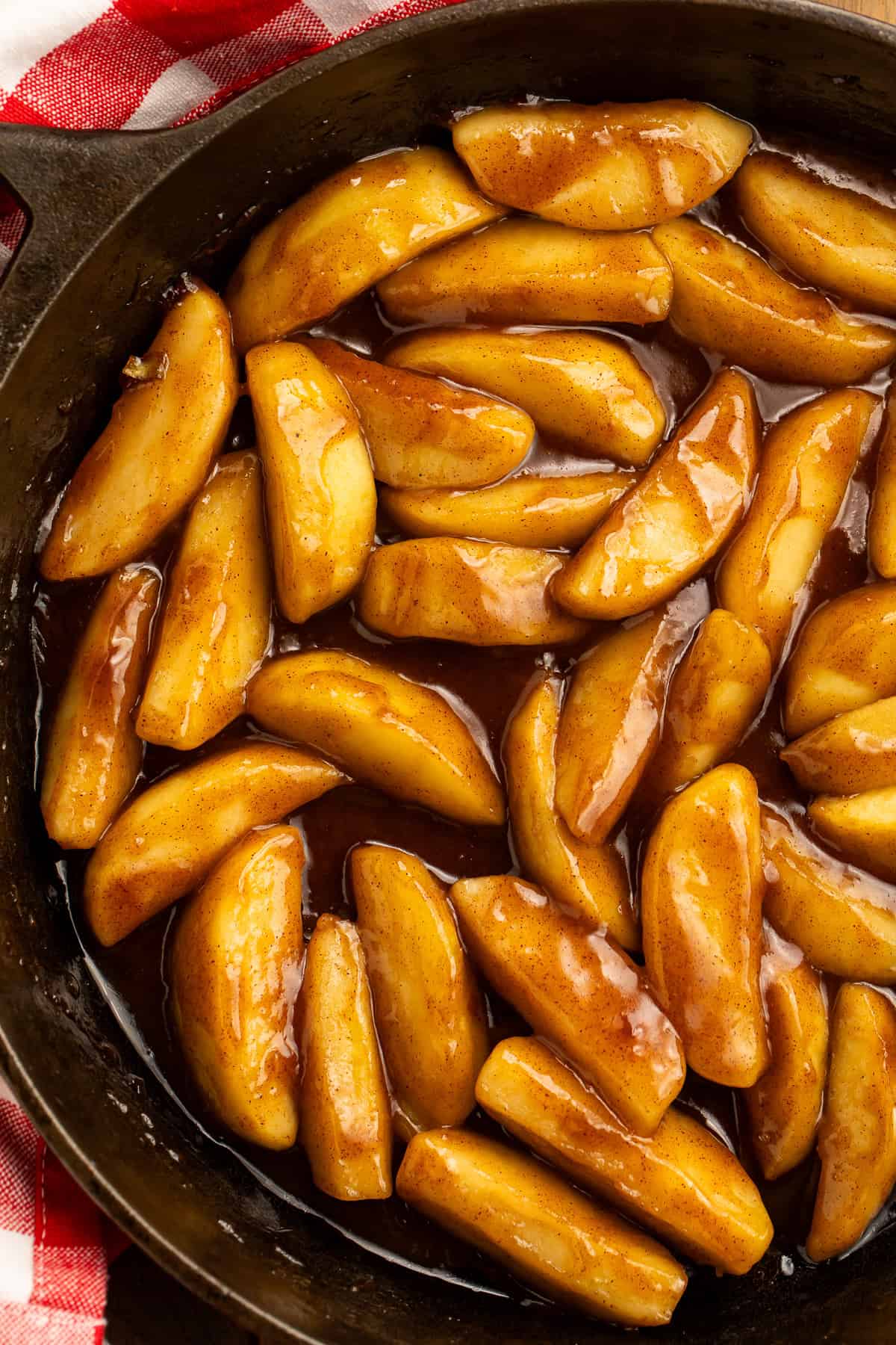 Copycat Cracker Barrel fried apples in a cast-iron skillet with cinnamon glaze.