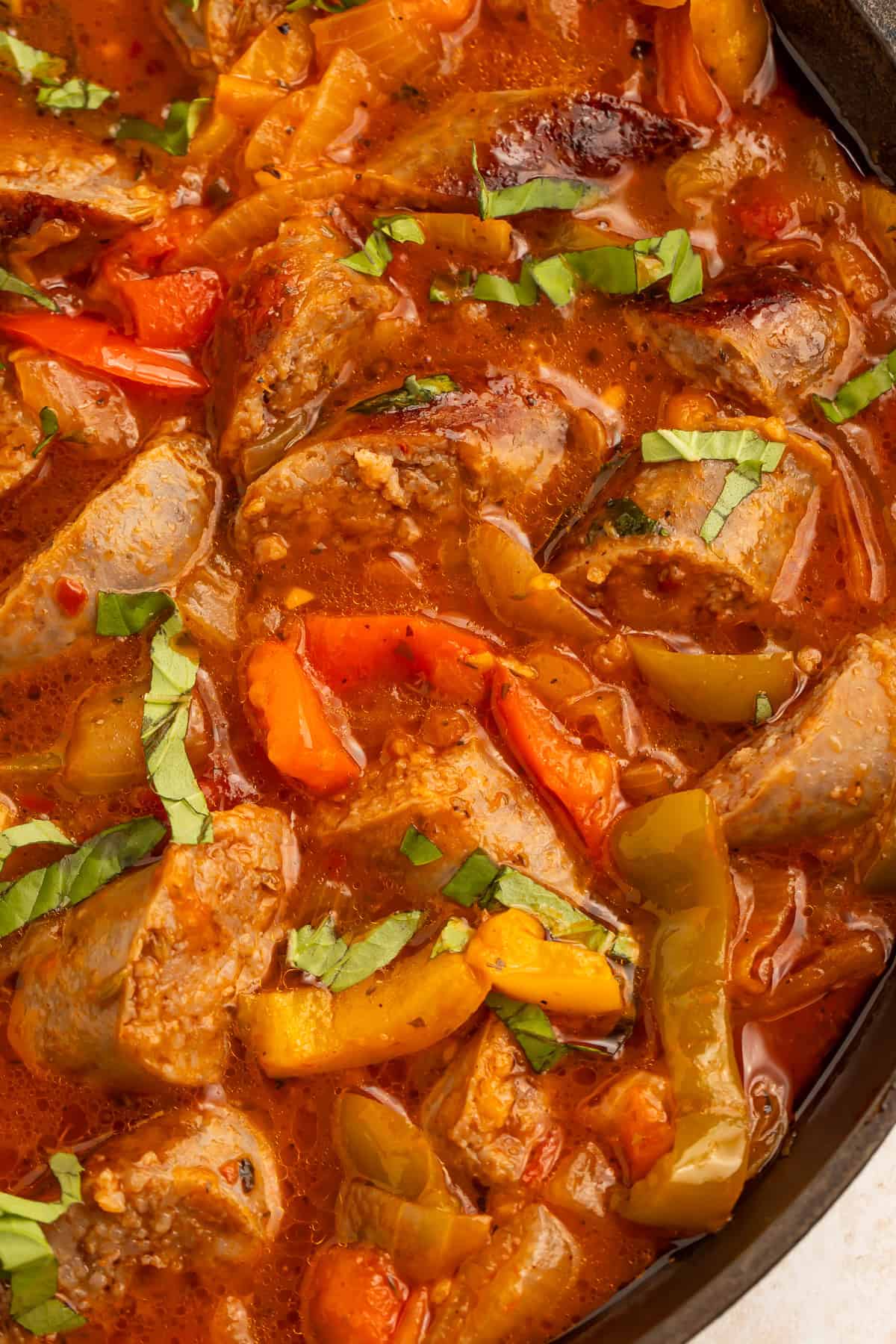 Instant Pot sausage and peppers in tomato sauce with sliced Italian sausage, bell peppers, onions, and fresh basil.