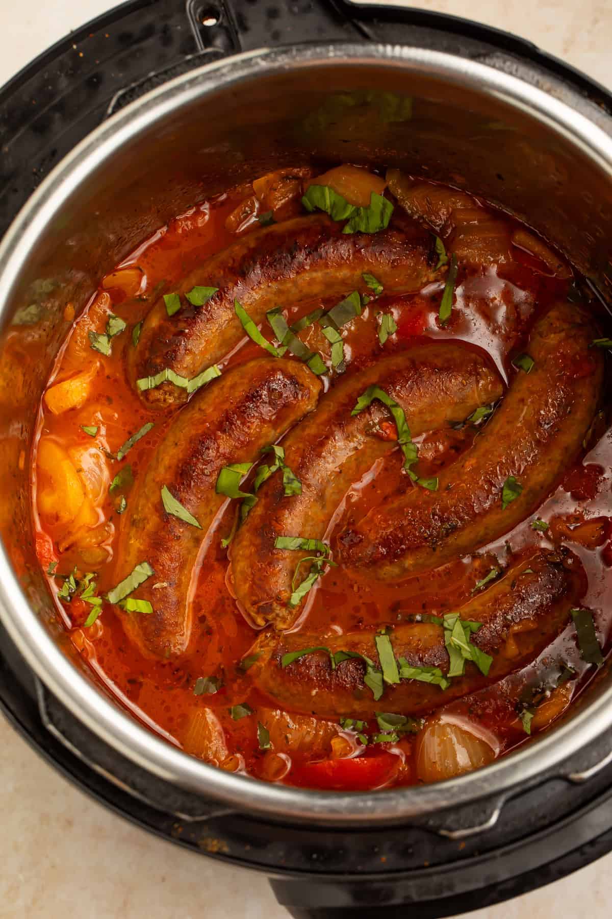 Instant Pot sausage and peppers with whole Italian sausages, bell peppers, onions, tomato sauce, and fresh basil.