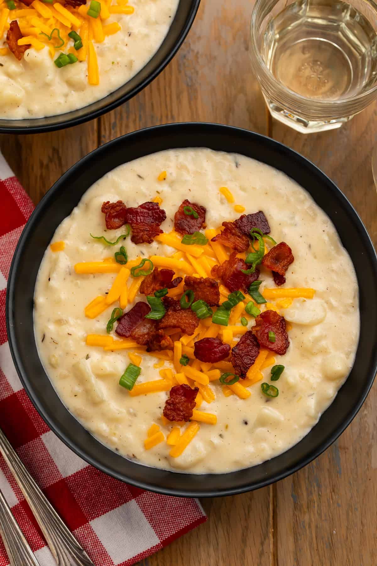 Copycat Outback Steakhouse potato soup topped with bacon, Colby Jack cheese, and green onions.