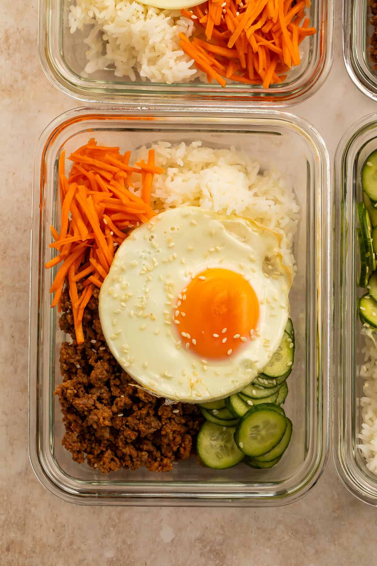 Korean ground beef bowls with rice, carrots, cucumbers, and sesame-topped fried eggs
