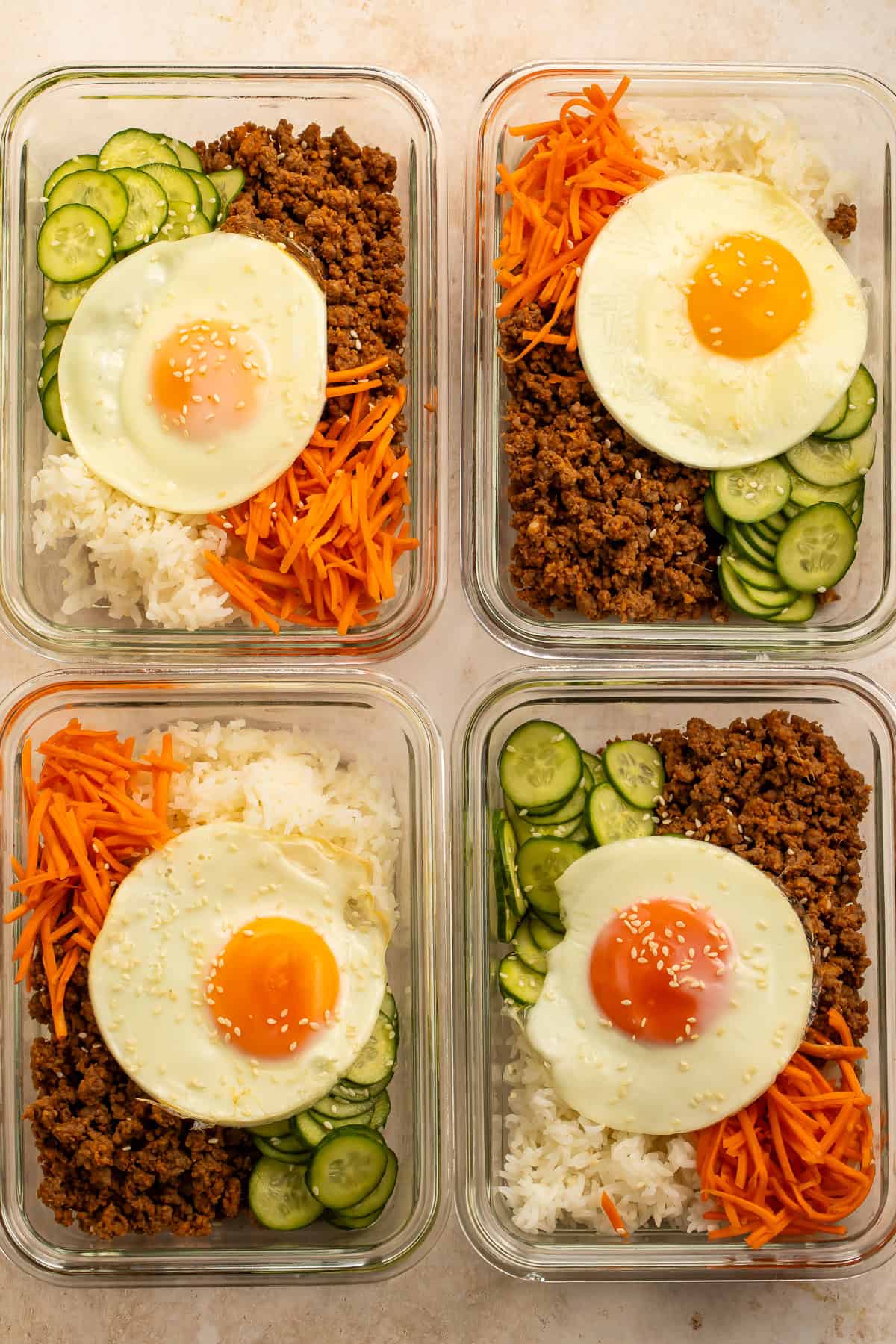 Korean beef meal prep bowl with jasmine rice, pickled carrots, sesame cucumbers, and a fried egg