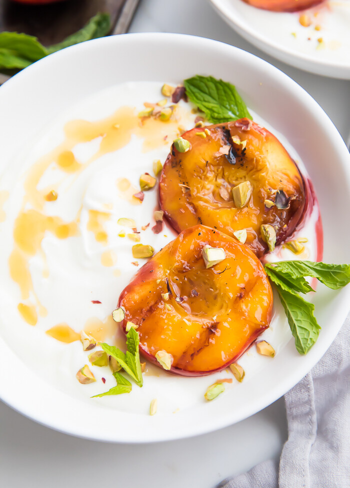 Grilled peaches on a bowl of yogurt with honey
