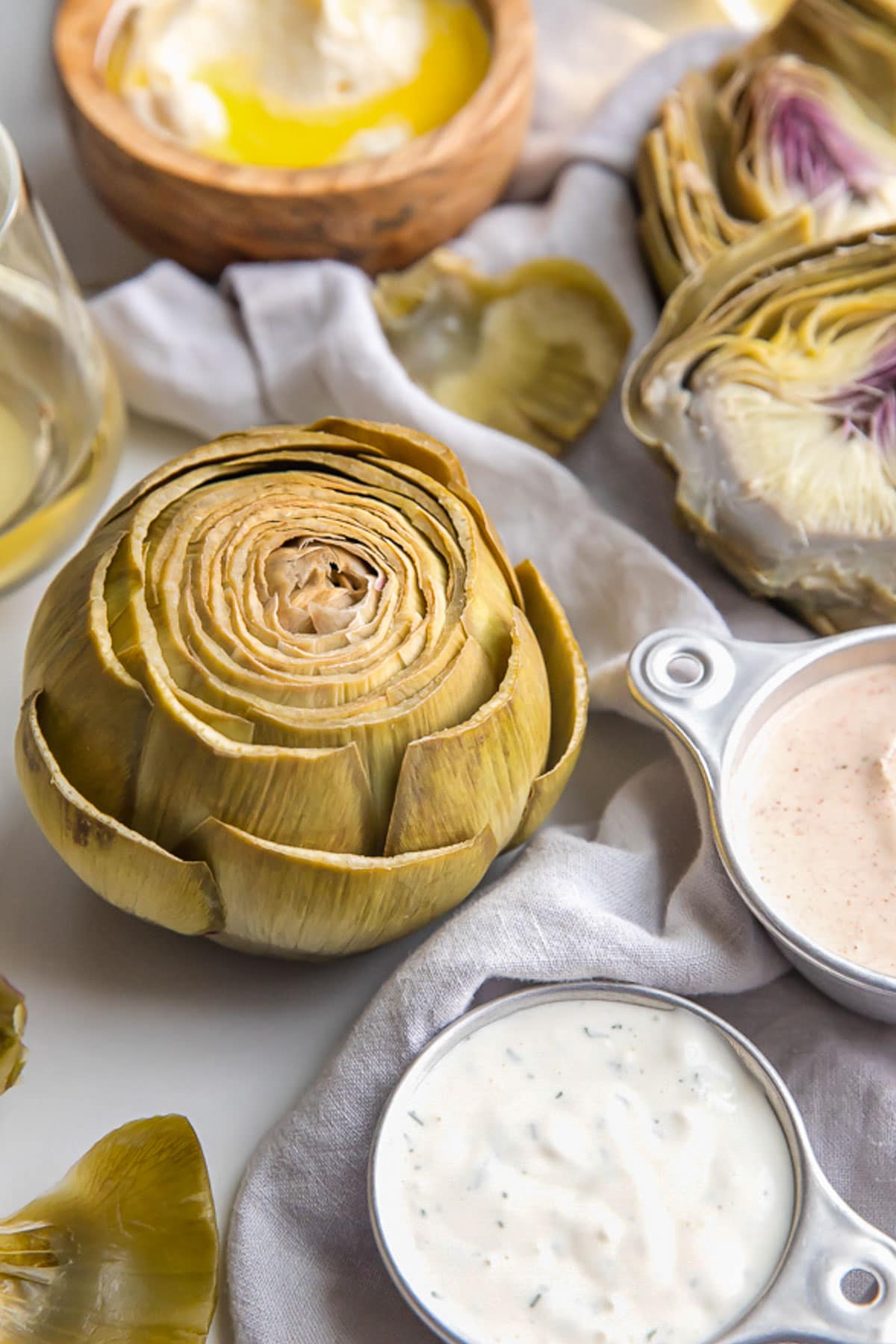 Boiled artichokes with three types of dipping sauces.