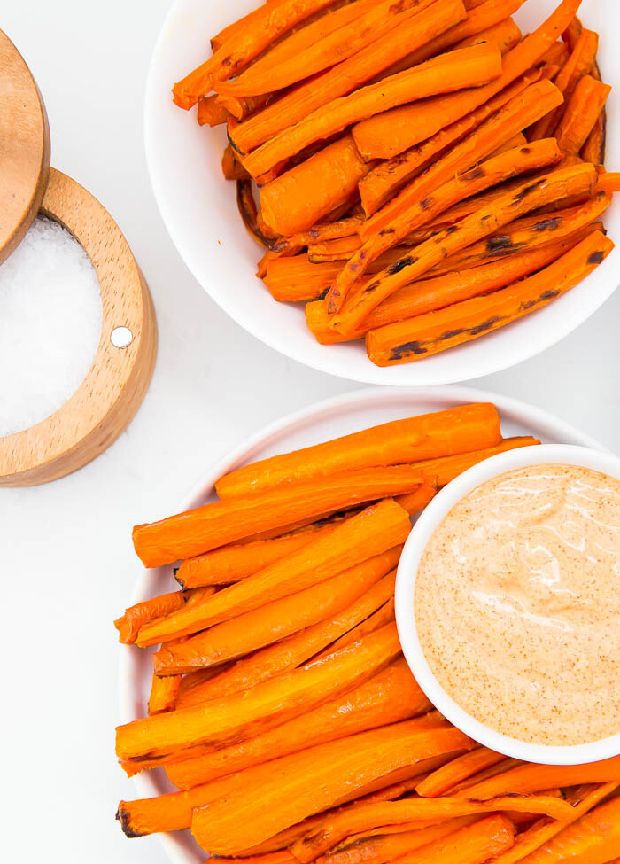 two plates of carrot fries with paprika sauce