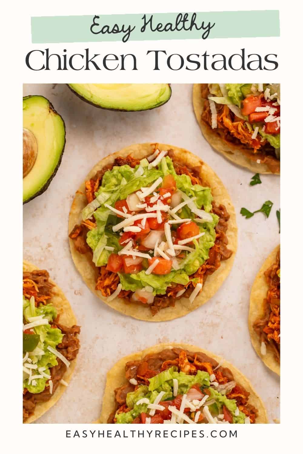 Top down picture of healthy chicken tostadas with refried beans, guacamole and salsa with a Pinterest text overlay.
