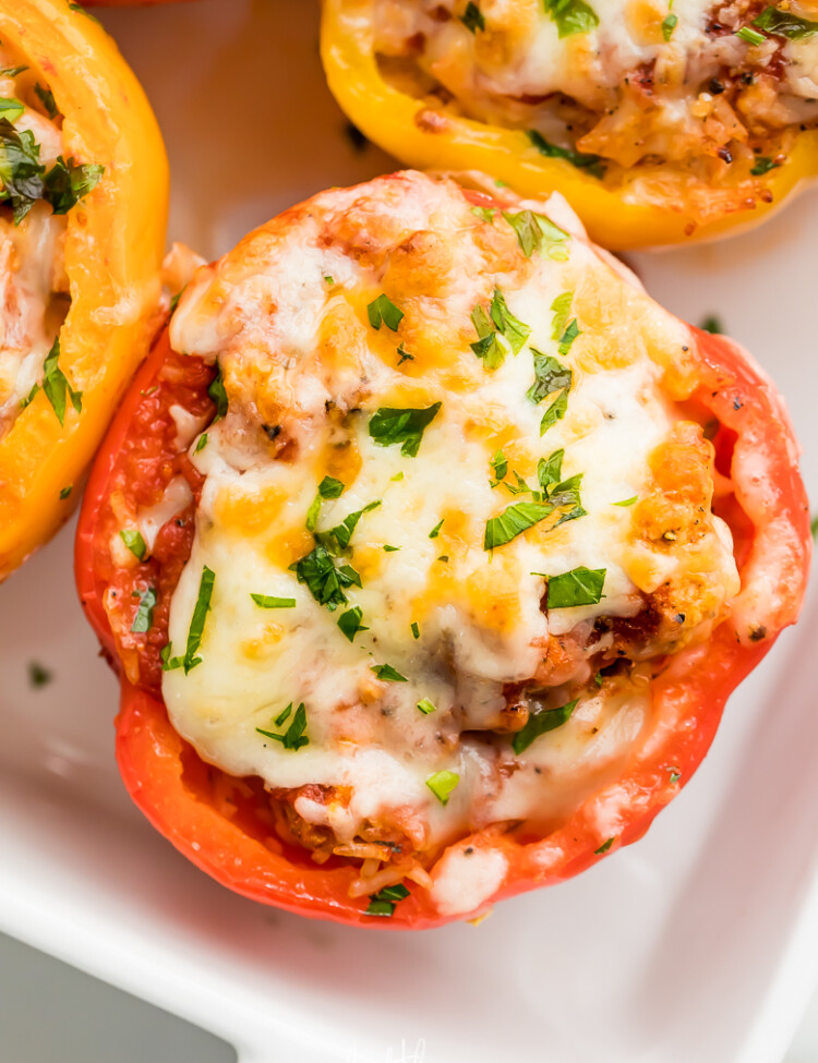 Turkey Stuffed Peppers with melted cheese and fresh parsley. Served in white dish.