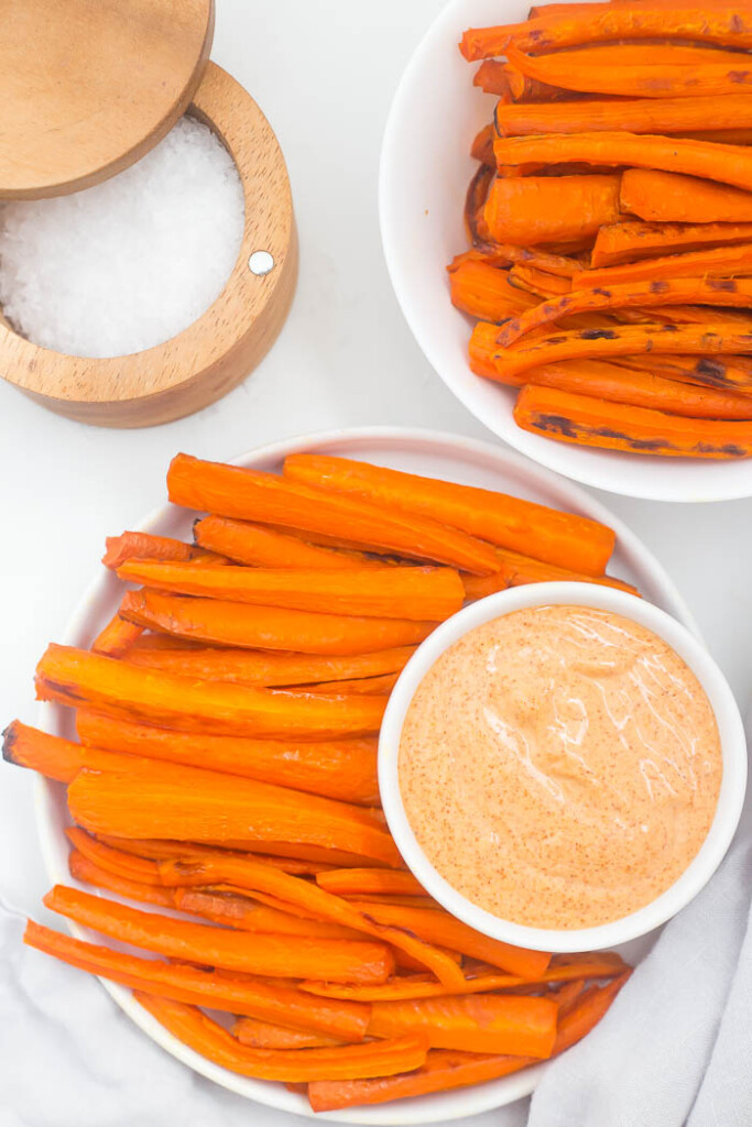Plate and bowl of carrot fries with sea salt and creamy paprika sauce.
