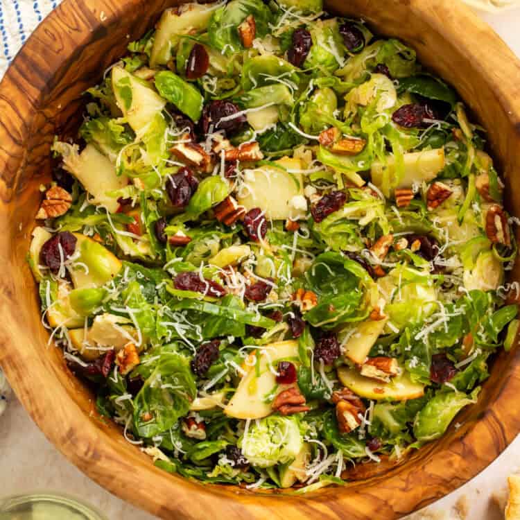 Wooden bowl of a shredded brussels sprouts salad.