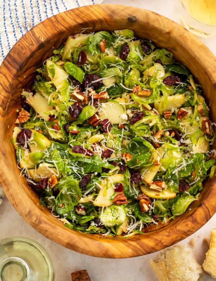 Wooden bowl of a shredded brussels sprouts salad.