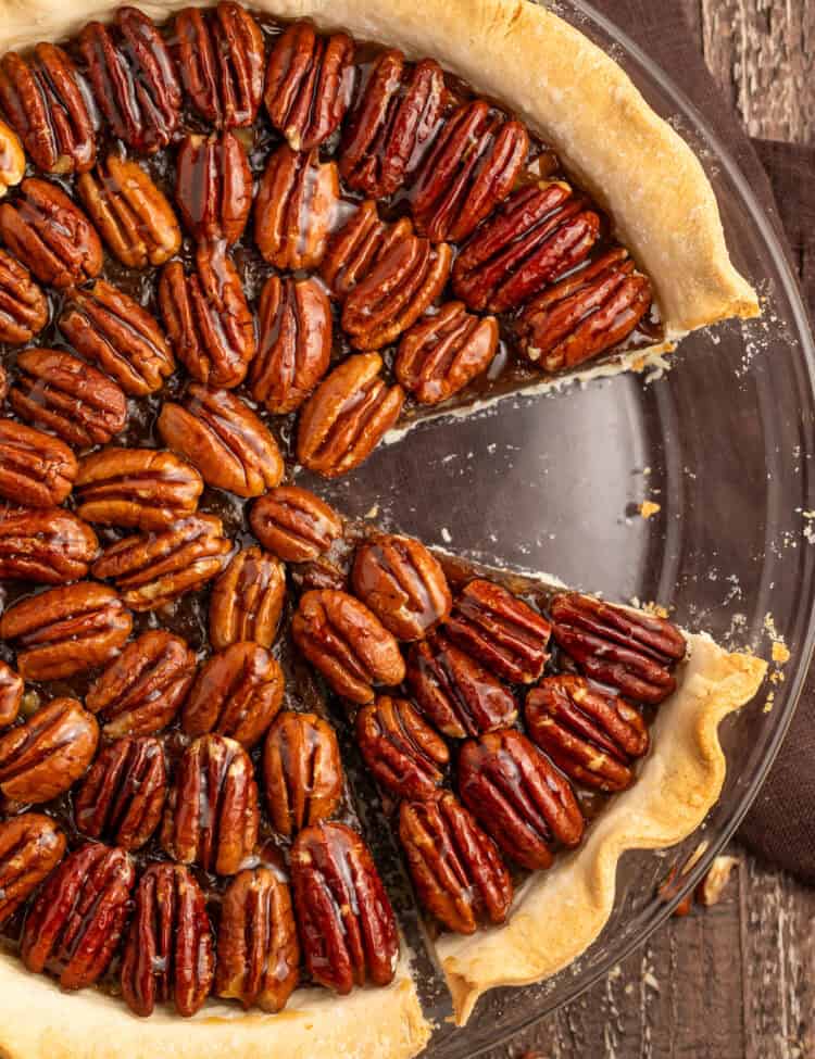 Top down photo of a vegan pecan pie with a slice missing.