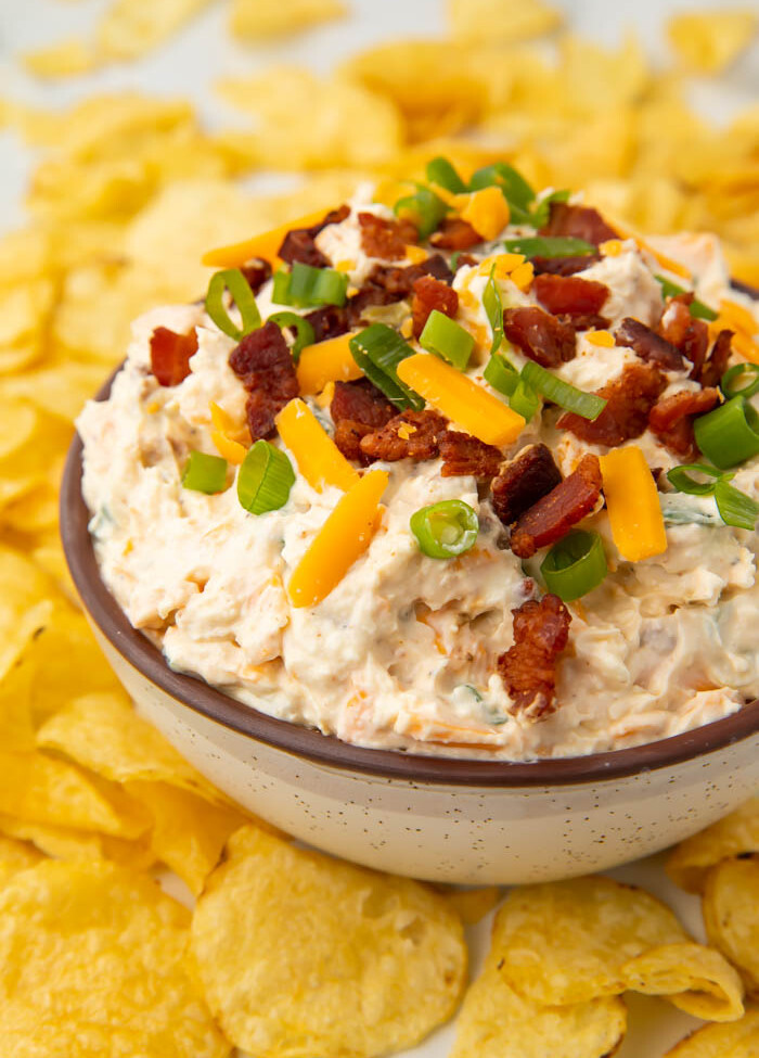 Bowl of loaded baked potato dip surrounded by chips