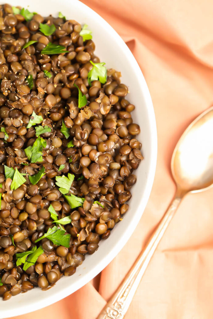 Bowl of French green lentils with a spoon