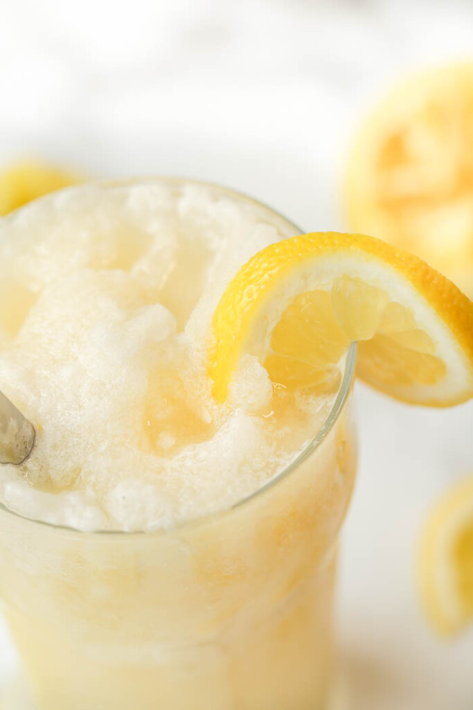 Close-up of glass of frozen lemonade with a lemon wedge