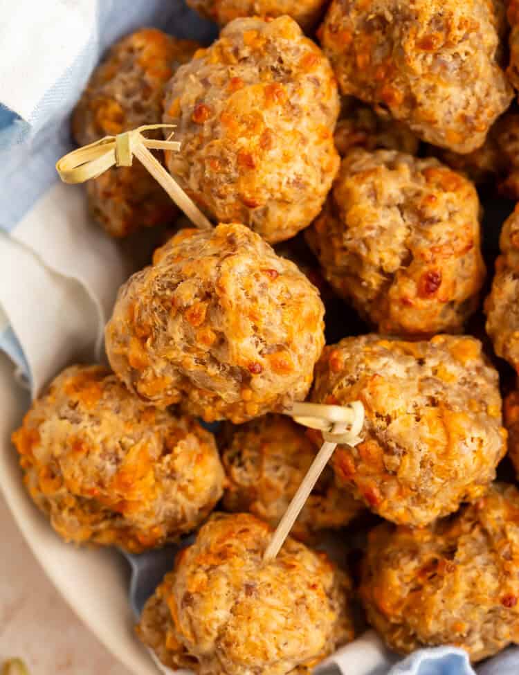Close up of cream cheese stuffing balls with toothpicks in a blue and white cloth-lined basket.