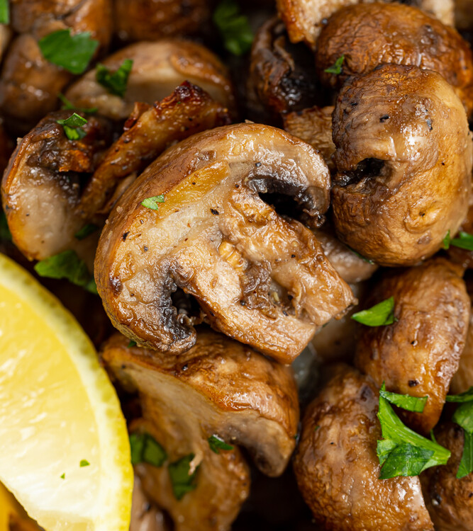 close up image of air fryer mushrooms topped with fresh parsley