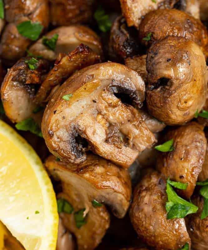 close up image of air fryer mushrooms topped with fresh parsley