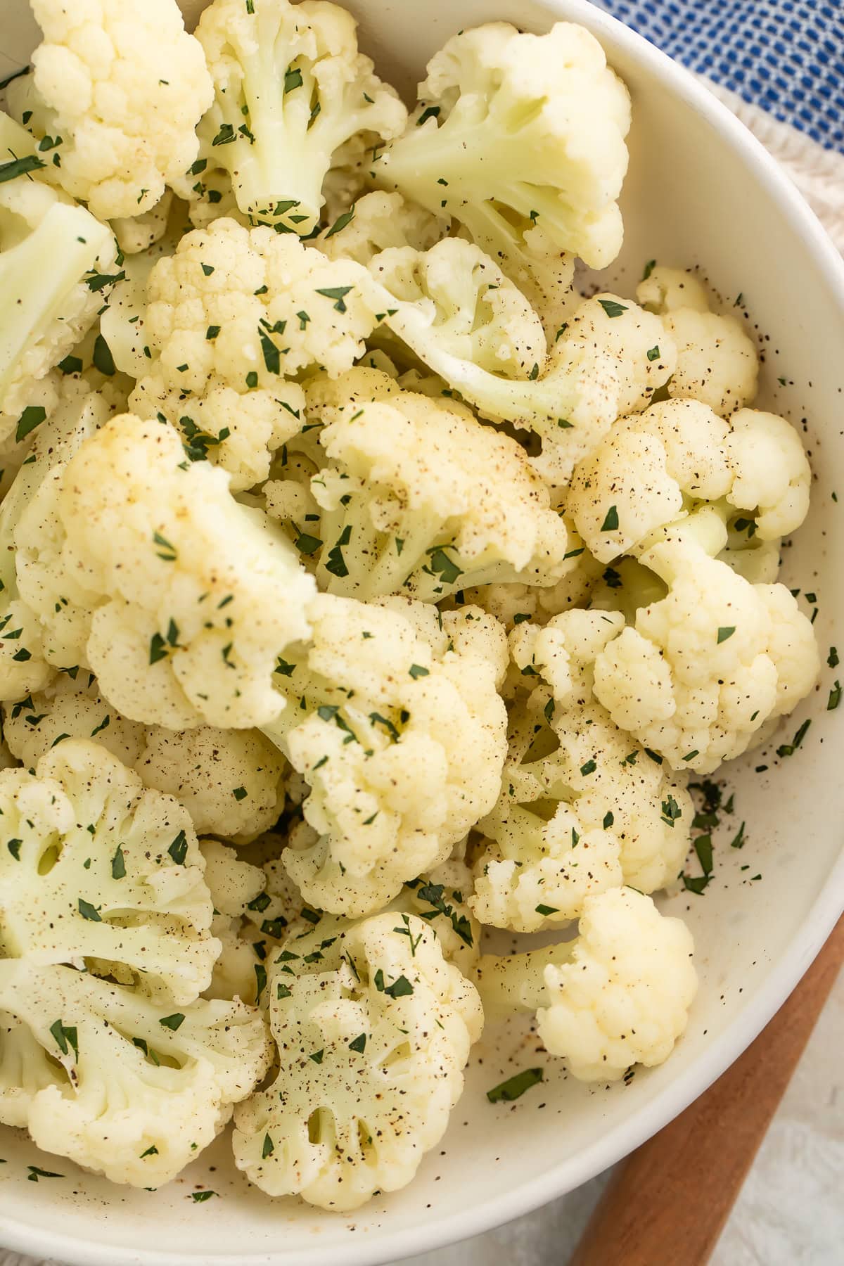 Close-up of a large white bowl holding tender florets of Instant Pot Cauliflower.
