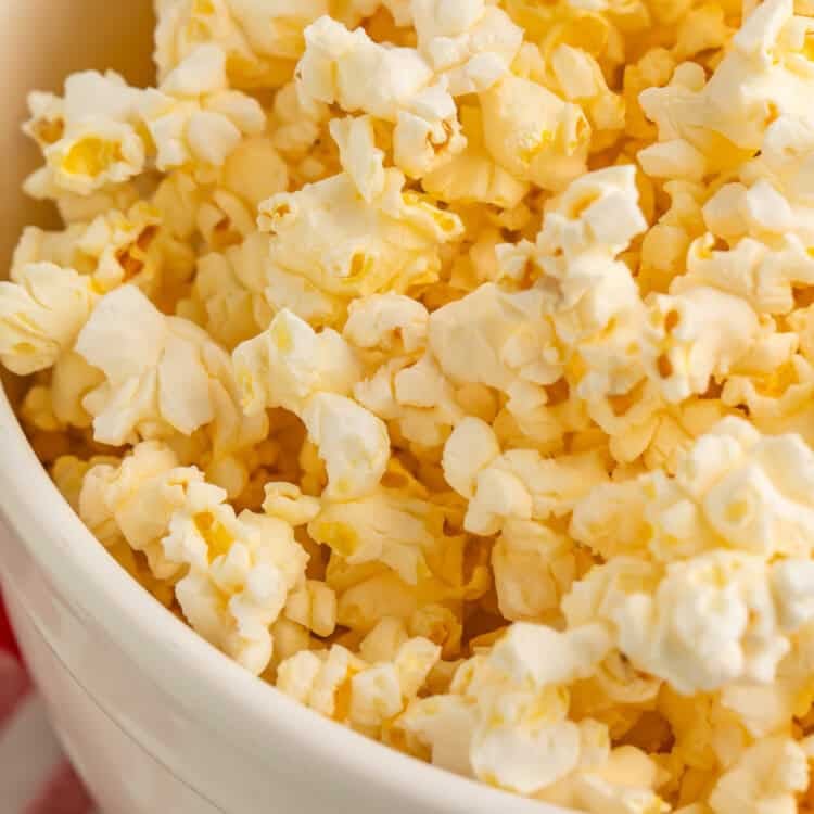 Close up of a white bowl of popcorn.