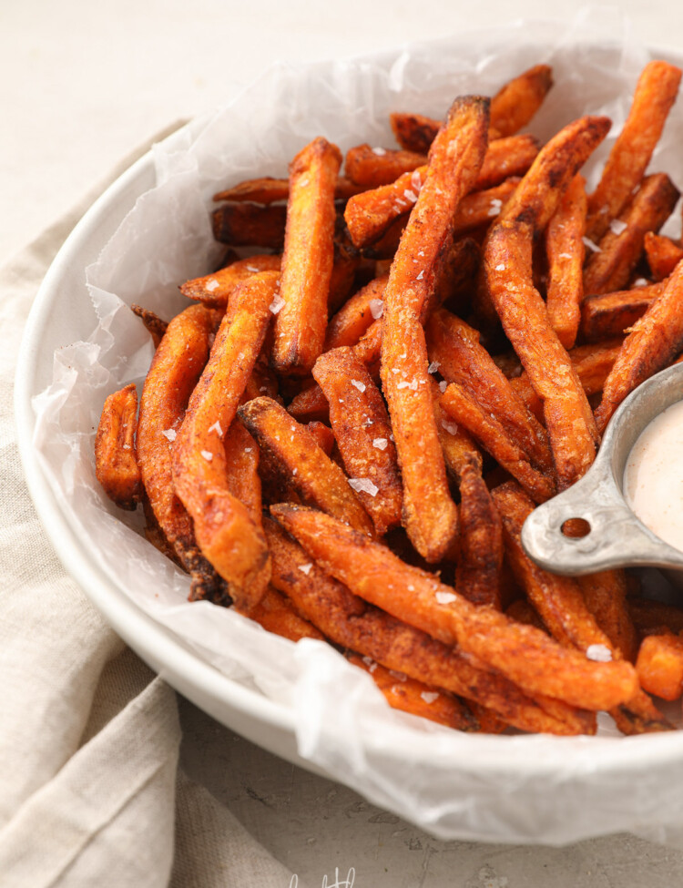 Sweet potato fries with salt in a white bowl