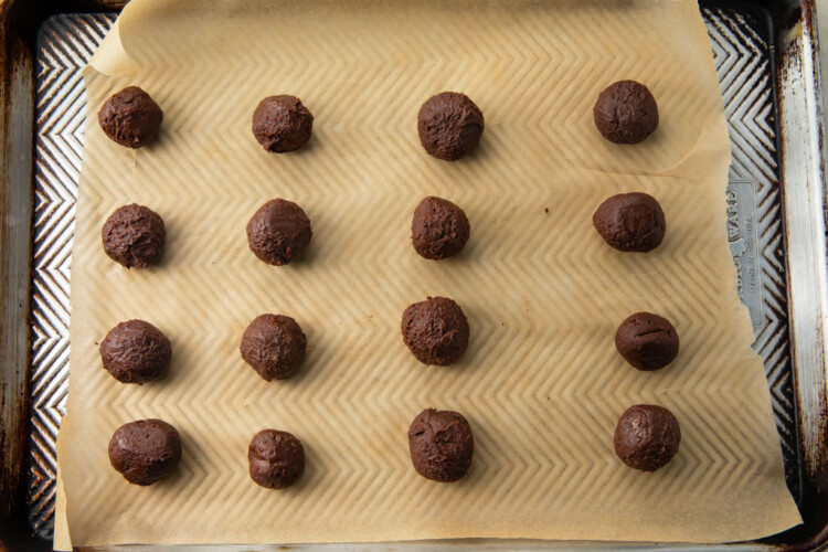 Rolled keto chocolate truffle balls on a parchment lined sheet pan