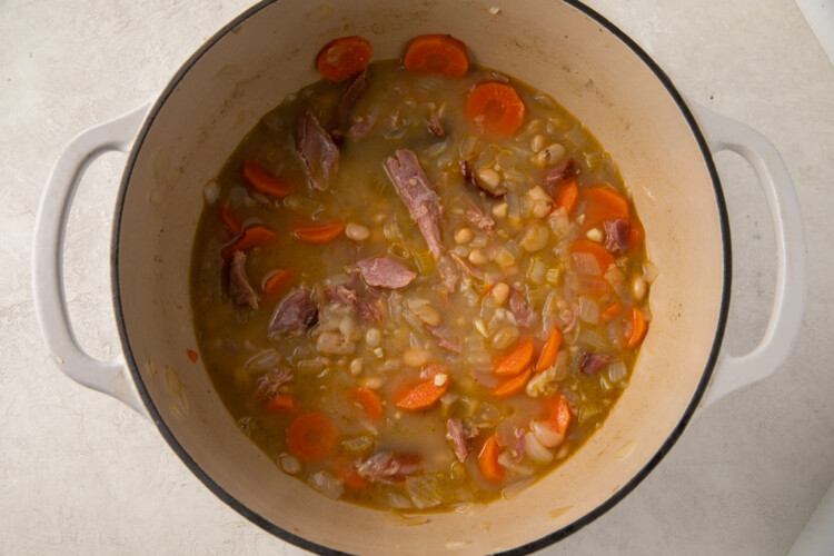 Large pot with broth, smoked turkey, carrots, celery, and seasoning.