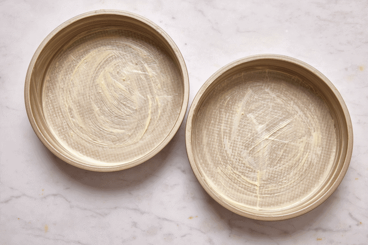 Two buttered and lined cake pans.