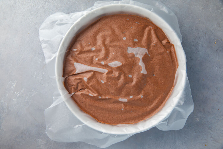 Bowl of set chocolate pudding covered by parchment paper