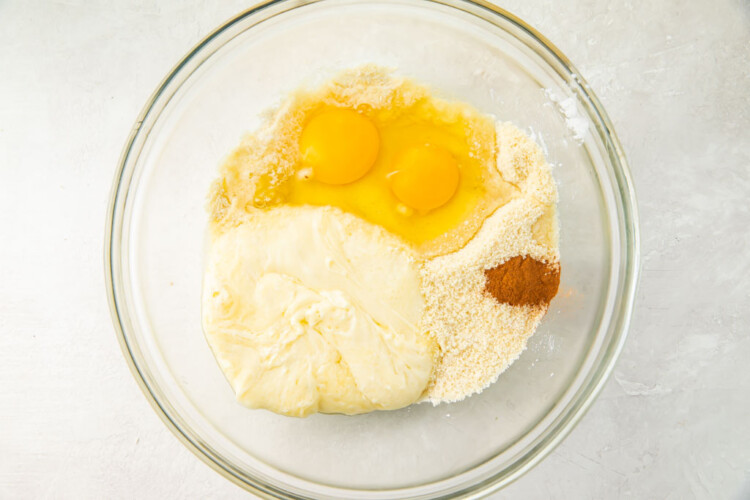 Cinnamon, eggs, almond flour, erythritol, and baking powder in a glass bowl