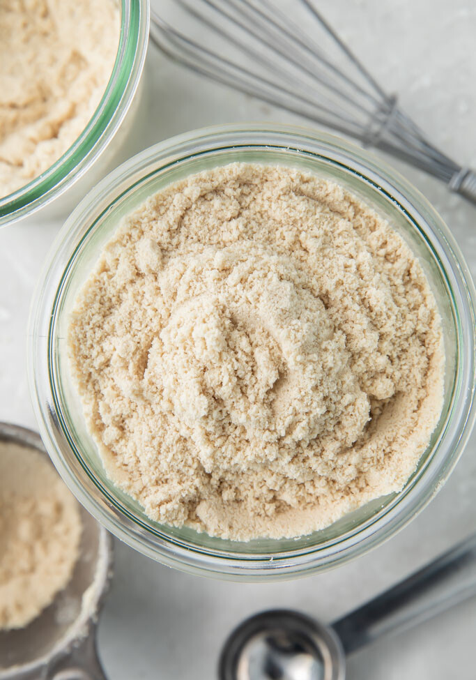 Keto flour mix in a glass jar surrounded by cooking utensils