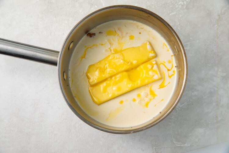 Two sticks of butter and heavy cream in a silver saucepan