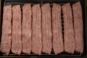Raw turkey bacon on a baking rack