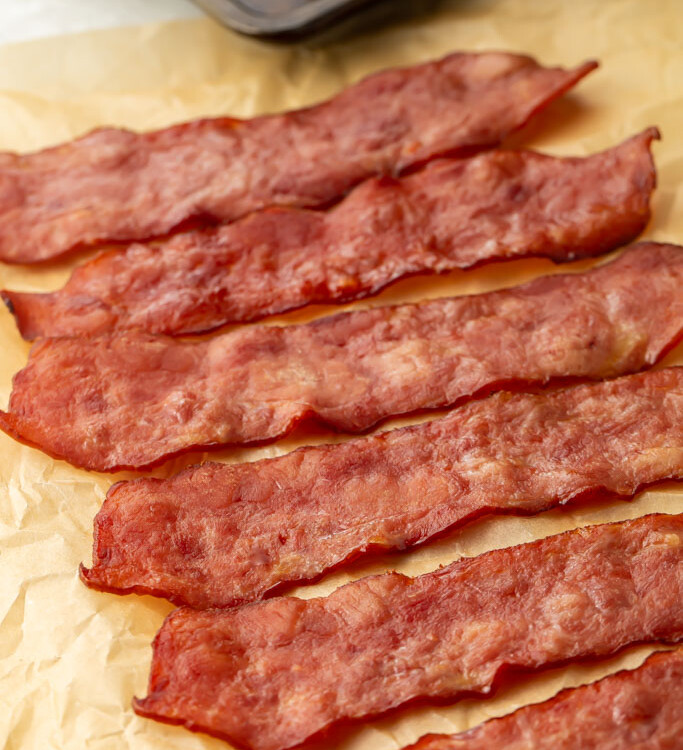 6 slices of turkey bacon laid diagonally across a sheet of parchment paper