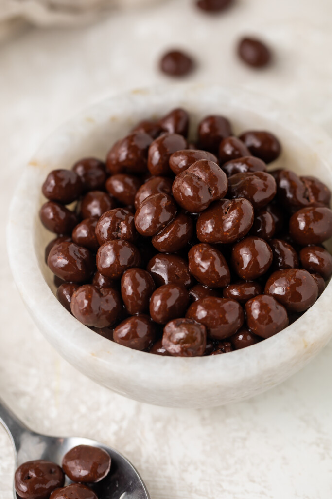 Chocolate covered espresso beans in a small white bowl