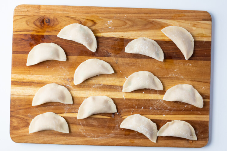 Closed and sealed chicken gyoza on a cutting board
