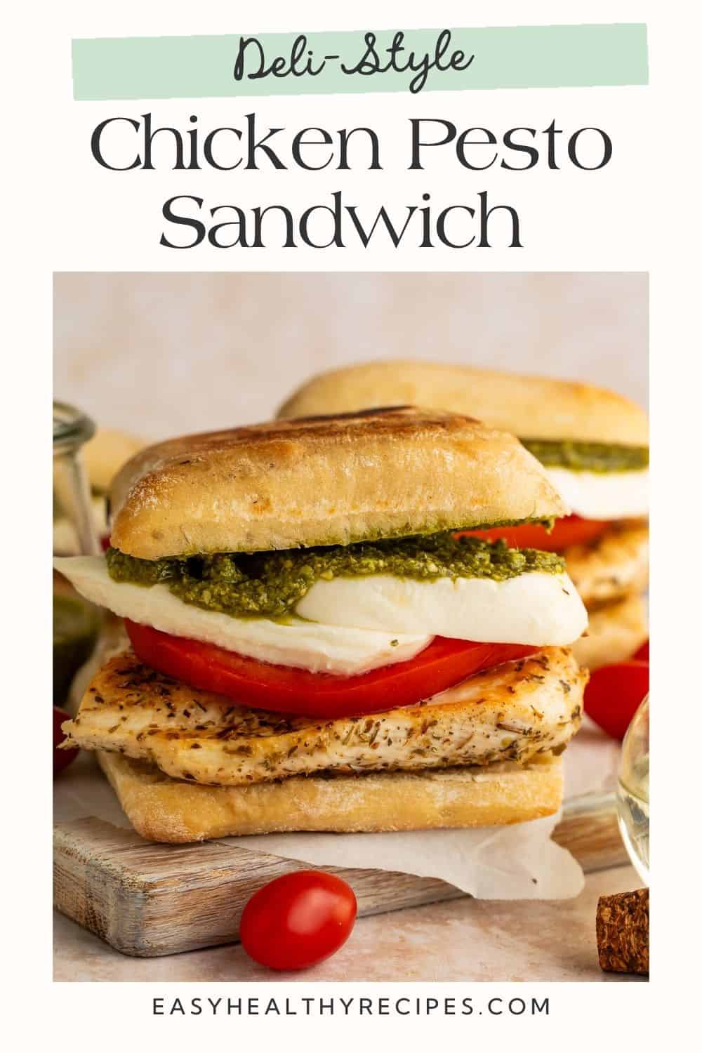 Two chicken, pesto, tomato and mozzarella toasted ciabatta sandwiches on a cutting board with Pinterest-friendly text overlaid on the frame.