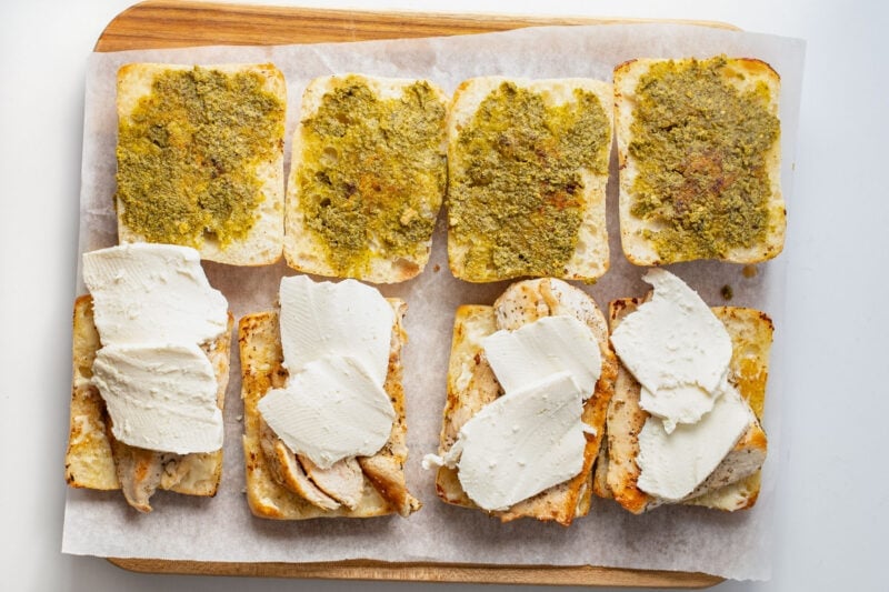 Slices of mozzarella placed on top of chicken cutlets for chicken pesto sandwiches.