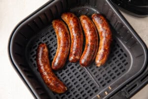 Cooked sausages in an air fryer basket